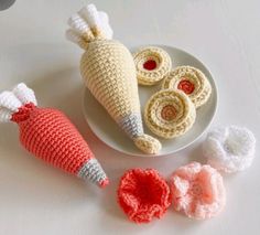 three crocheted items are sitting on a white plate next to some small ones