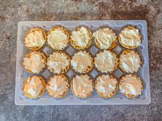 cupcakes with white frosting sitting on top of a plastic tray