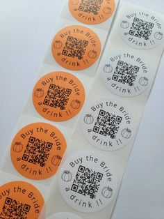 four orange and white stickers with qr - code on them, one for drink