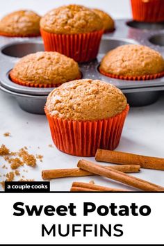 several muffins sitting on top of a pan with cinnamon sticks next to them