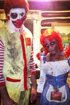 two people dressed in costumes standing next to each other, one wearing a clown mask