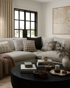 a living room with a large sectional couch and coffee table in front of a window