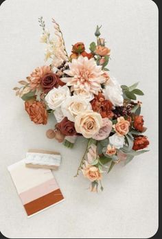 a bouquet of flowers and a card on a white surface with a color swatch