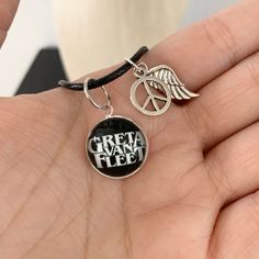 🎶 And the black smoke rises, From the fires we've been told, It's the new age crisis 🎶 As a companion piece to my studs here is a Greta Van Fleet charm necklace. Boasting the bands logo in white on a black background, together with a silver peace sign and silver feather charms. Size: 16mm Chain: Black cord Greta Van Fleet Jewelry, Adjustable Black Necklace With Charms, Adjustable Black Charm Necklace, Greta Van Fleet Black And White, Adjustable Black Sterling Silver Charm Necklaces, Greta Van Fleet Sweatshirt, Music-themed Black Jewelry Gift, Black Music-themed Jewelry For Gift, Greta Van Fleet Anthem Of The Peaceful