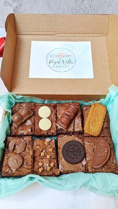 a box filled with brownies and cookies on top of a table