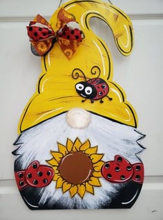 a painted door hanger with ladybugs and sunflowers on the front