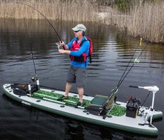 a man standing on top of a boat holding a fishing pole and two fish rods