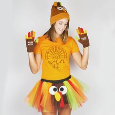 a girl wearing a turkey costume with her hands in the air