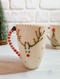 three coffee mugs decorated with christmas decorations