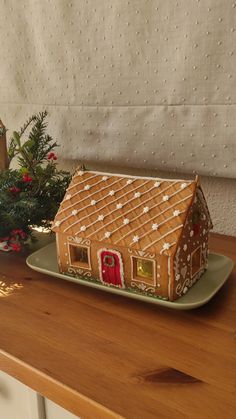 a gingerbread house sitting on top of a green plate