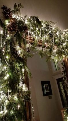 a christmas wreath with lights and pine cones hanging from the ceiling