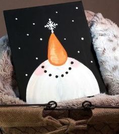 a painting of a snowman with a hat on it's head sitting in a basket