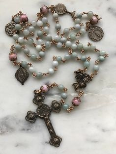 This is a beautiful wire-wrapped heirloom rosary! Beads: 6mm jade and 8mm rhodonite gemstones Medals: Bronze Wire: 20 gauge solid bronze Extra medals: Blessed Sacrament Birth of Jesus Sacred Heart Stella Maris Spiritual Wire Wrapped Rosary As Gift, Spiritual Gift Wire Wrapped Rosary, Divine Mercy Chaplet Rosary, Beautiful Rosaries, Jesus Sacred Heart, Hair Accessories Braids, Divine Mercy Chaplet, Holy Spirit Dove, Chaplet Rosary