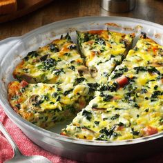 a casserole with spinach and cheese in a pan on a wooden table