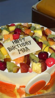 a happy birthday cake with fruit on it