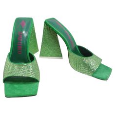 Step into sophistication with The Attico Green Devon Heeled Sandals—an exquisite pair of shoes that redefine glamour with every step. These green suede heeled mules are not just shoes; they're a dazzling display of craftsmanship and style. Picture yourself in these heeled sandals with tonal crystal cut detailing throughout. The open square toe adds a modern touch, while the printed logo in pink at the padded buffed goatskin footbed provides a subtle nod to the brand's identity. The leather outso