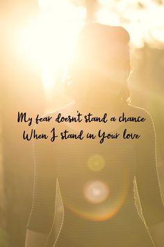 a woman standing in front of the sun with her back turned to the camera and texting my fear doesn't stand a chance when i stand in your love