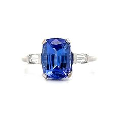 an oval cut blue sapphire and diamond ring with two baguets on each side