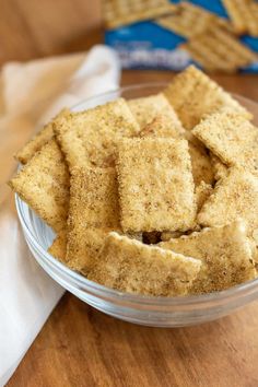 a glass bowl filled with crackers on top of a wooden table