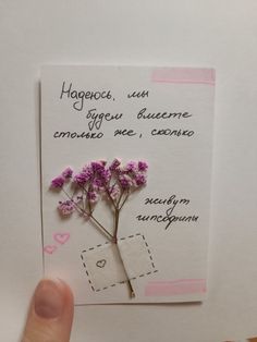 a hand holding up a piece of paper with flowers on it and the words happy birthday written in spanish