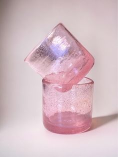 two pink glass cups sitting on top of each other