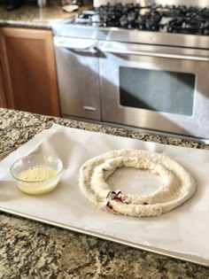 a doughnut sitting on top of a white paper towel next to a glass bowl