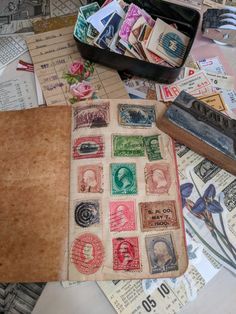 some stamps are laying on top of old envelopes and other mailing material that is scattered around