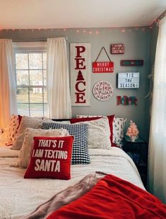 a bedroom decorated in red, white and grey with christmas decorations on the wall above the bed