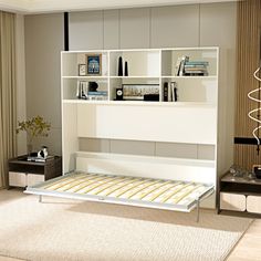 a white bed sitting in a bedroom next to a wall mounted book shelf and window