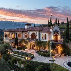 this is an aerial view of a luxury home at dusk with the sun setting in the background