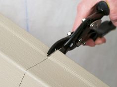 a person using pliers to trim a piece of wood