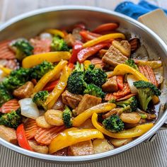 stir fry with broccoli, carrots, and other vegetables in a pan