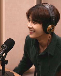 a man wearing headphones sitting in front of a microphone