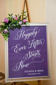 a purple sign that says happily ever after starts now with flowers on the top and bottom