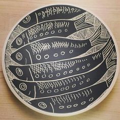 a black and white plate sitting on top of a wooden table