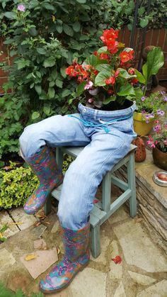 a person sitting on a bench with some flowers in their lap and wearing rain boots