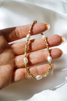 Our Saylor Pearl Bracelet is absolutely eye-catching! What do we love about it? The stunning gold beads mixed with the natural pearls make for a beautiful piece to stack with your other bracelets. Elevate your style with this elegant and versatile bracelet, perfect for adding a touch of sophistication to any look. Gift Pearl Bracelet With Faceted Rondelle Beads, Pearl Beaded Bracelets With Faceted Beads, Pearl Bracelets With Faceted Round Beads, Pearl Bracelets With Spacer Beads For Gifts, Dainty Pearl Bracelet With Faceted Round Beads, Gold Bohemian Pearl Bracelet, Minimalist 14k Gold-filled Beaded Bracelet With Pearl Charm, Dainty 14k Gold-filled Pearl Bracelet, Gold Beaded 14k Gold-filled Pearl Bracelet