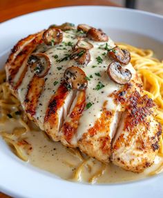 chicken with mushroom sauce and pasta on a white plate