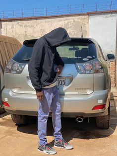 a man standing in front of a silver car