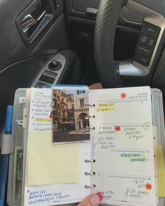 a person is holding a note book in their car