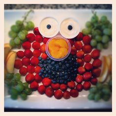 a plate topped with fruit and a face made to look like a bird