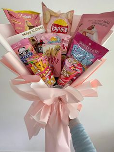 a pink vase filled with candy and snacks