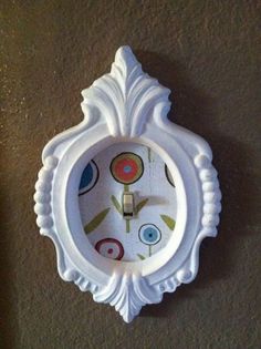 a white clock mounted to the side of a wall