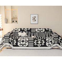 a black and white couch covered in a blanket