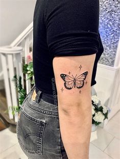 a woman with a butterfly tattoo on her arm