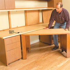 a man is working on an office desk with drawers and cupboards in the background