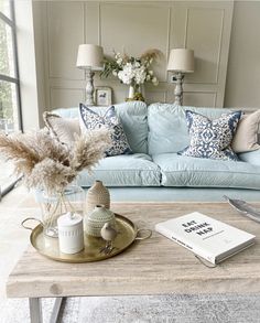 a living room with a blue couch and coffee table in front of a large window