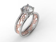 a white and rose gold engagement ring with an intricate design on the side, set in two