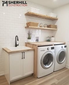 a washer and dryer sitting in a room next to a counter with baskets on it