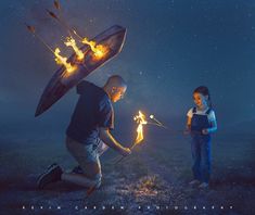 two people holding torches in their hands while looking at the sky with stars above them